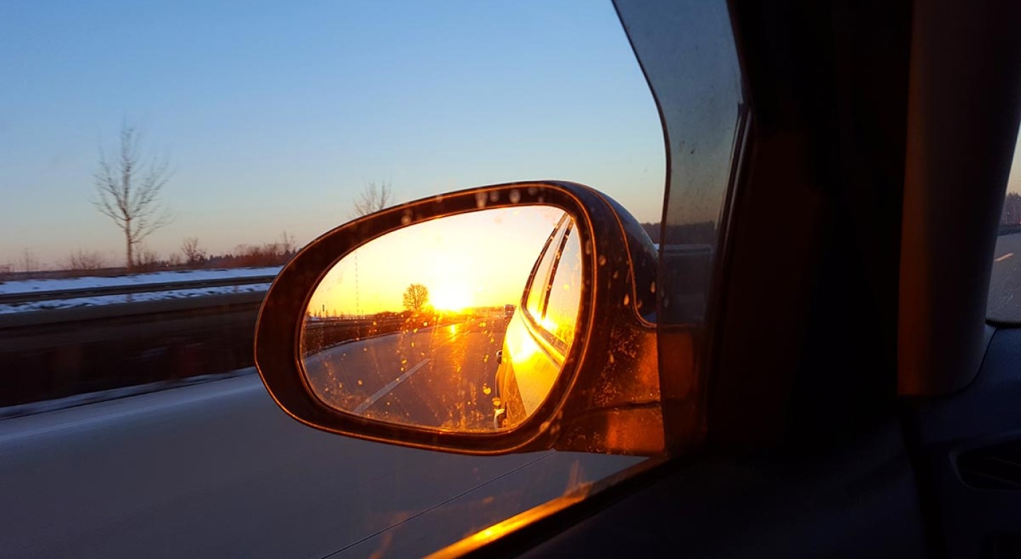 sunset reflected in car rearview mirror
