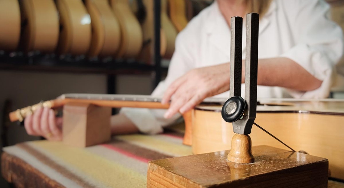 close up of woman tuning guitar