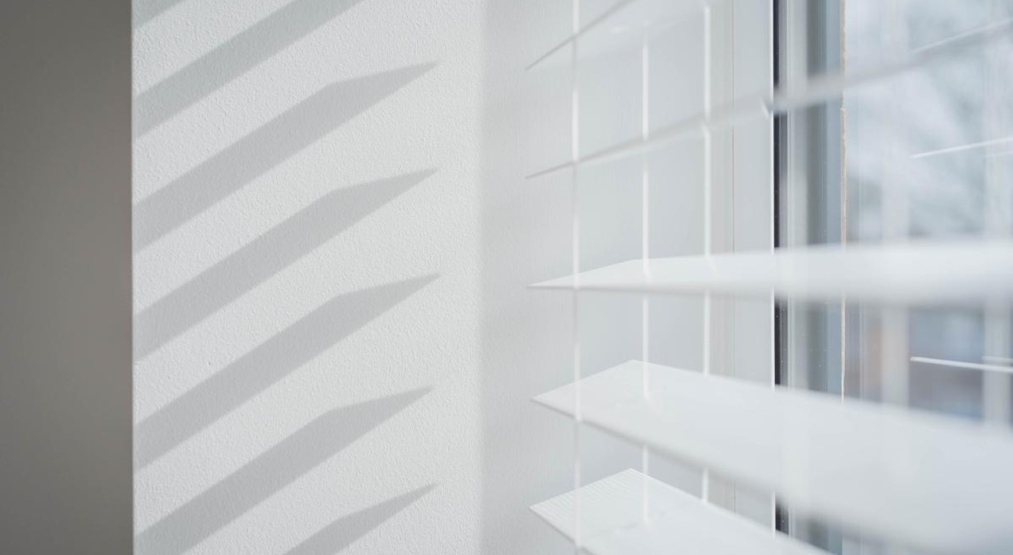 open white blinds creating shadow on wall