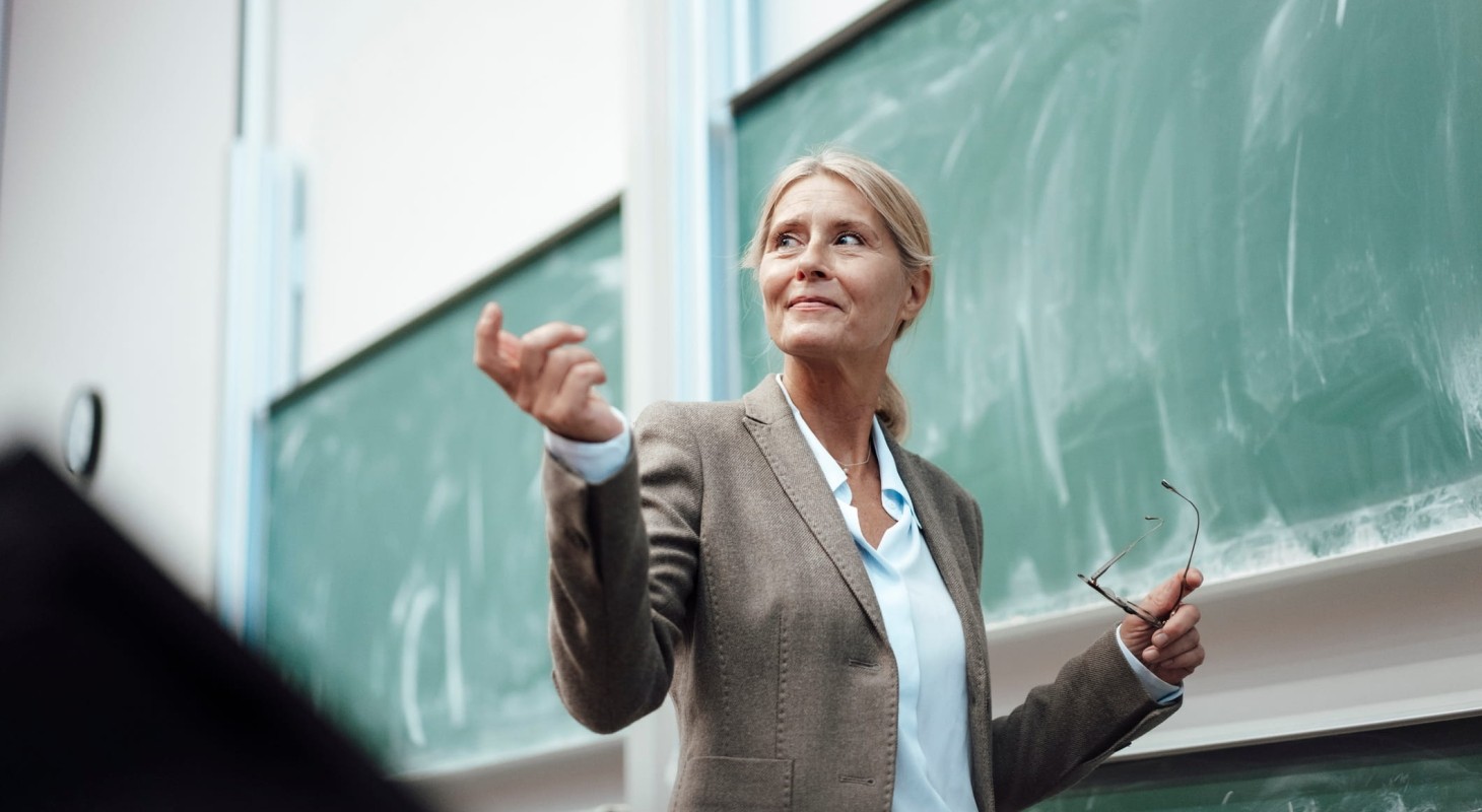 businesswoman giving presentation by chalkboard