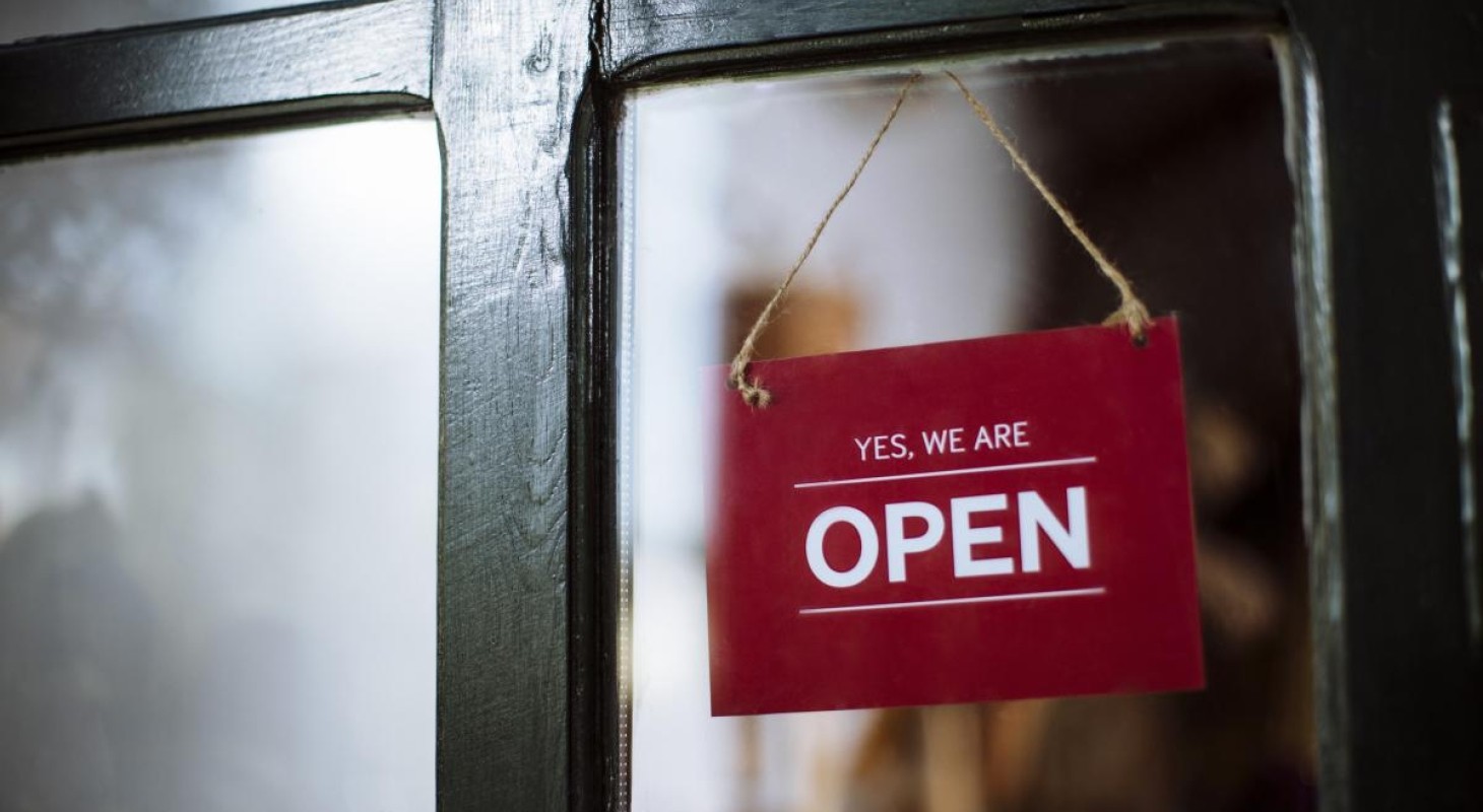 red sign hanging in window that says yes we are open