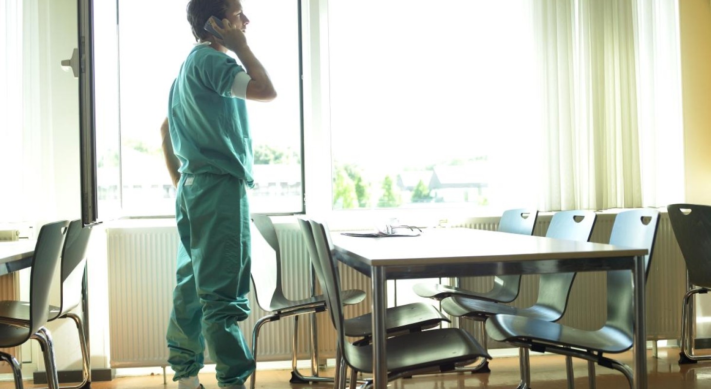 healthcare worker in green scrubs in hospital cafeteria