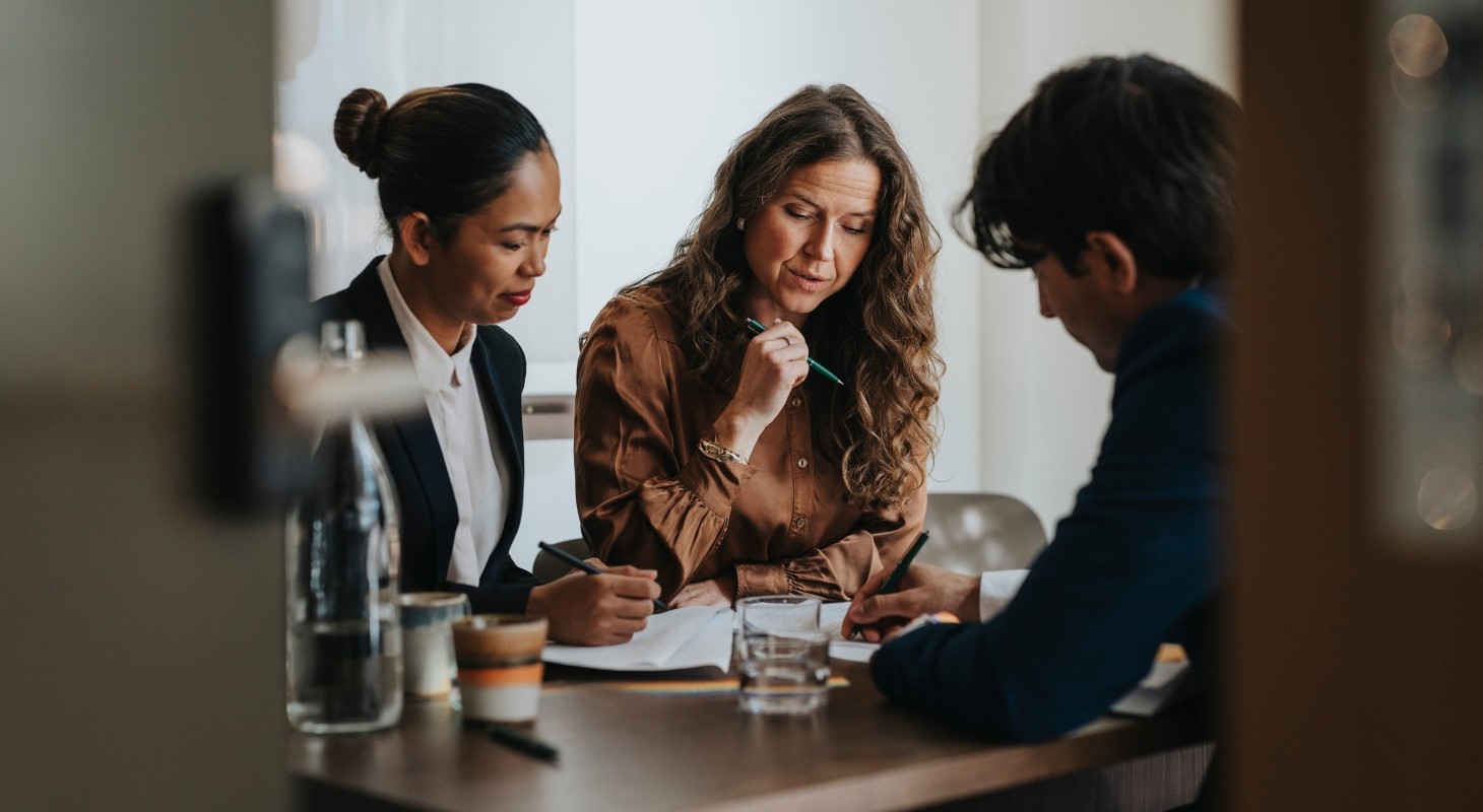 young businessman writing while discussing strategy