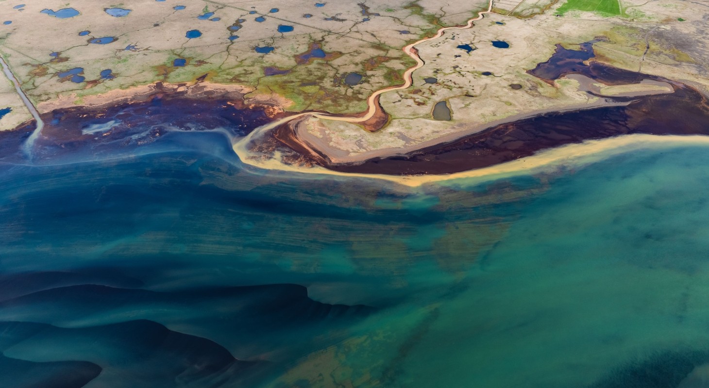 aerial shot of a coastal plain filled with blue ponds