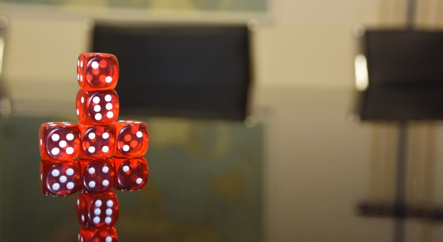red-dice-stacked-on-a-boardroom-table