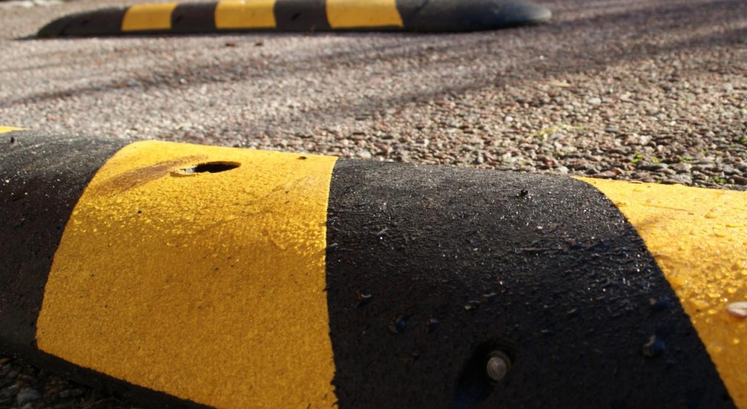 two black and yellow speedbumps in a road