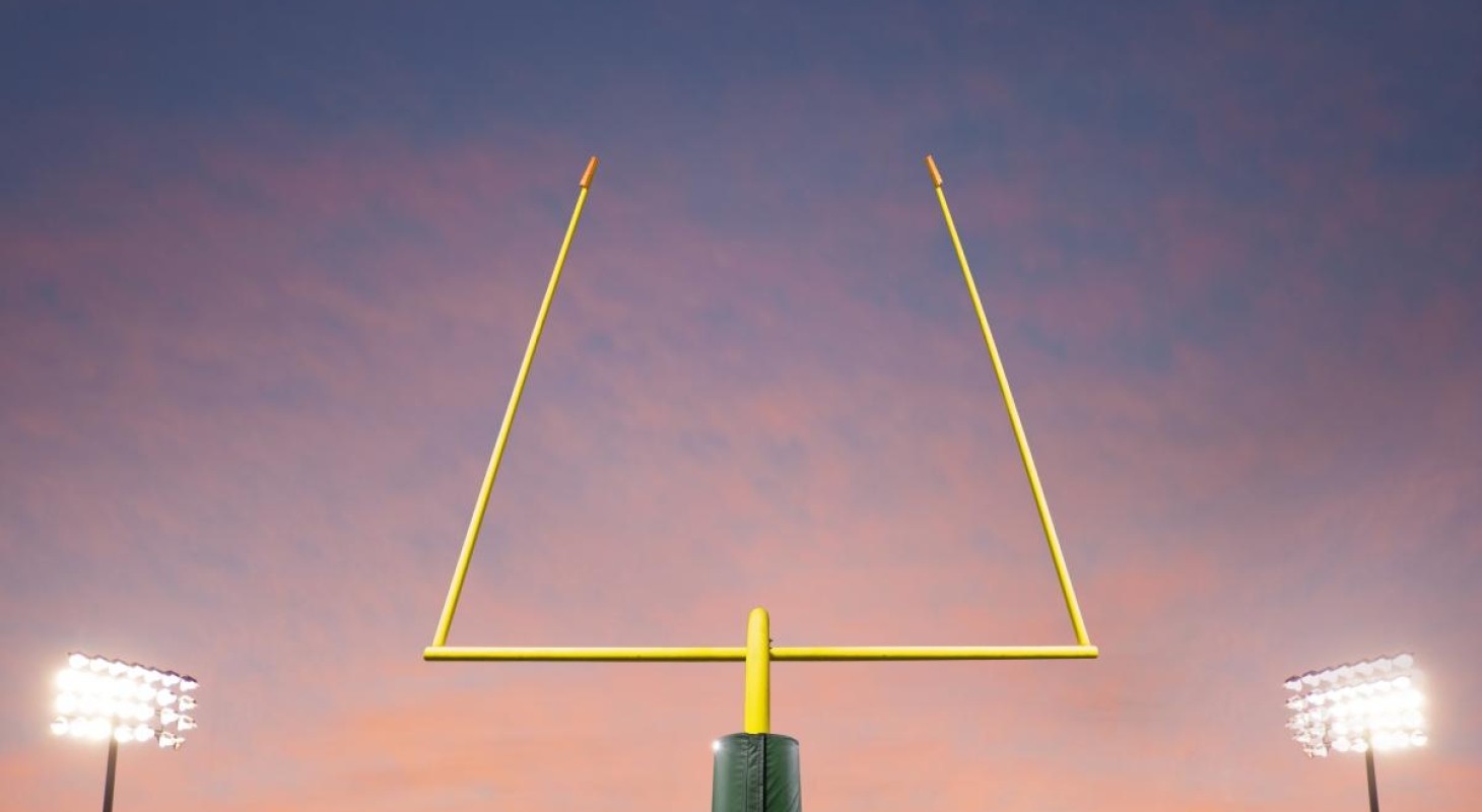 football goalpost and stadium lights against sunset background