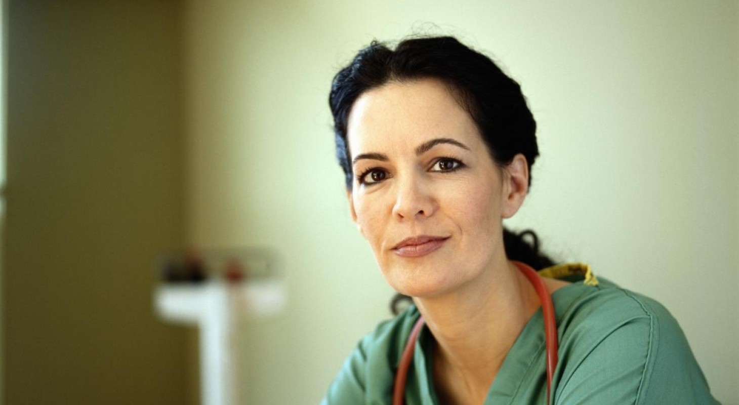 nurse in green scrubs with red stethoscope