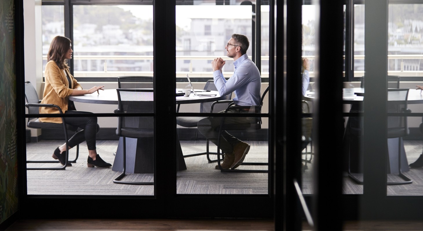 executives seated at conference table talking