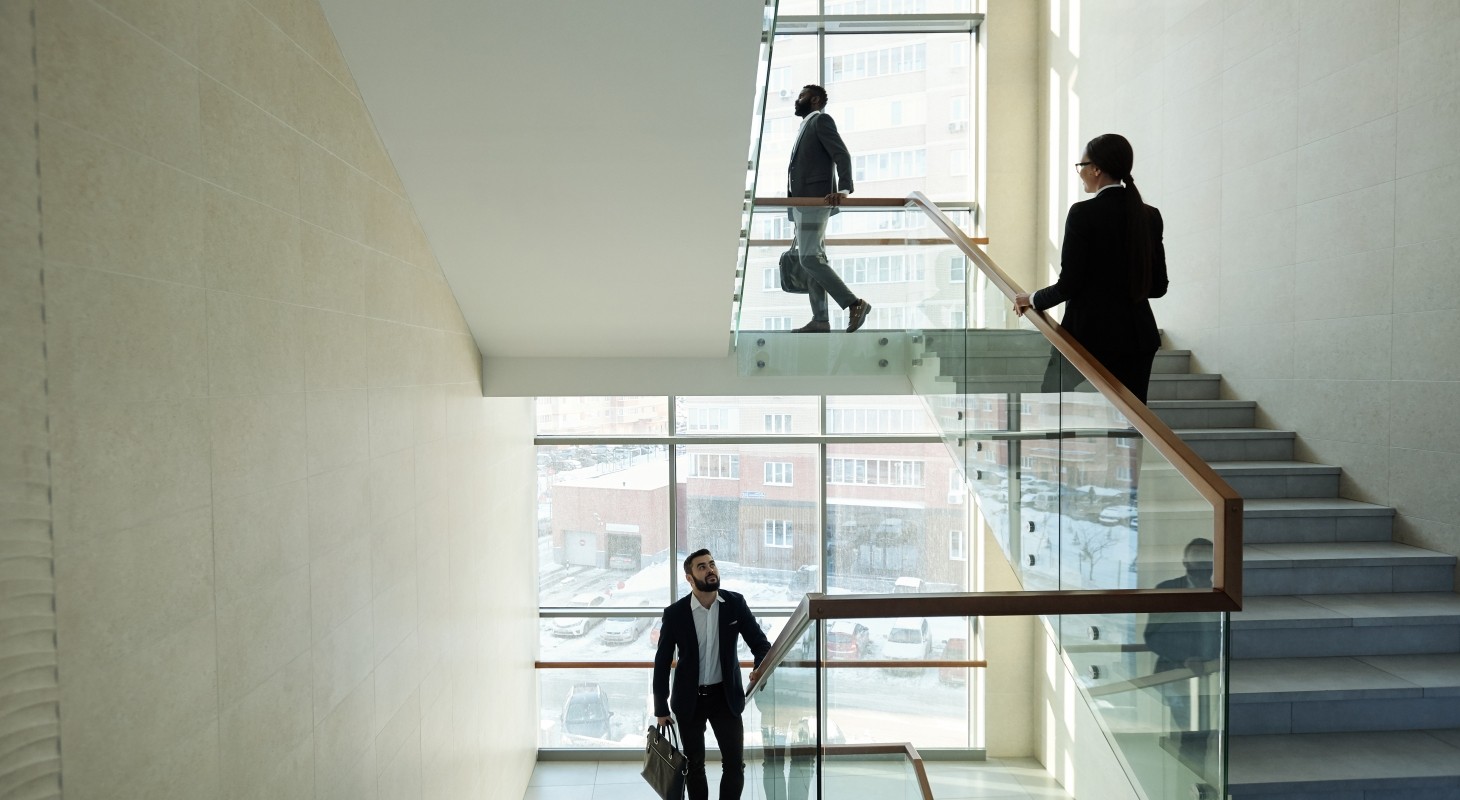 three young contemporary managers in large office center