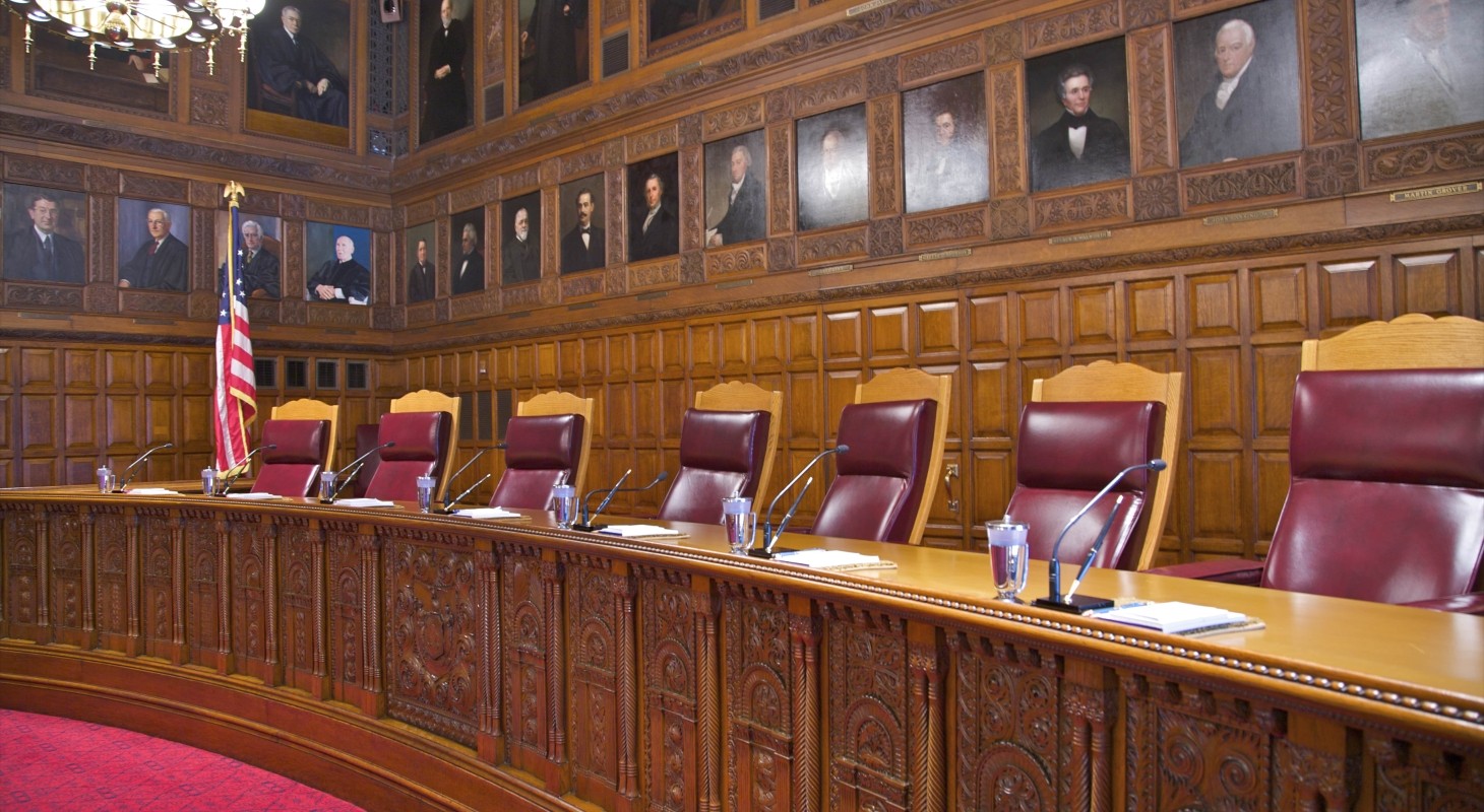 portraiture above carved wood deck in courtroom