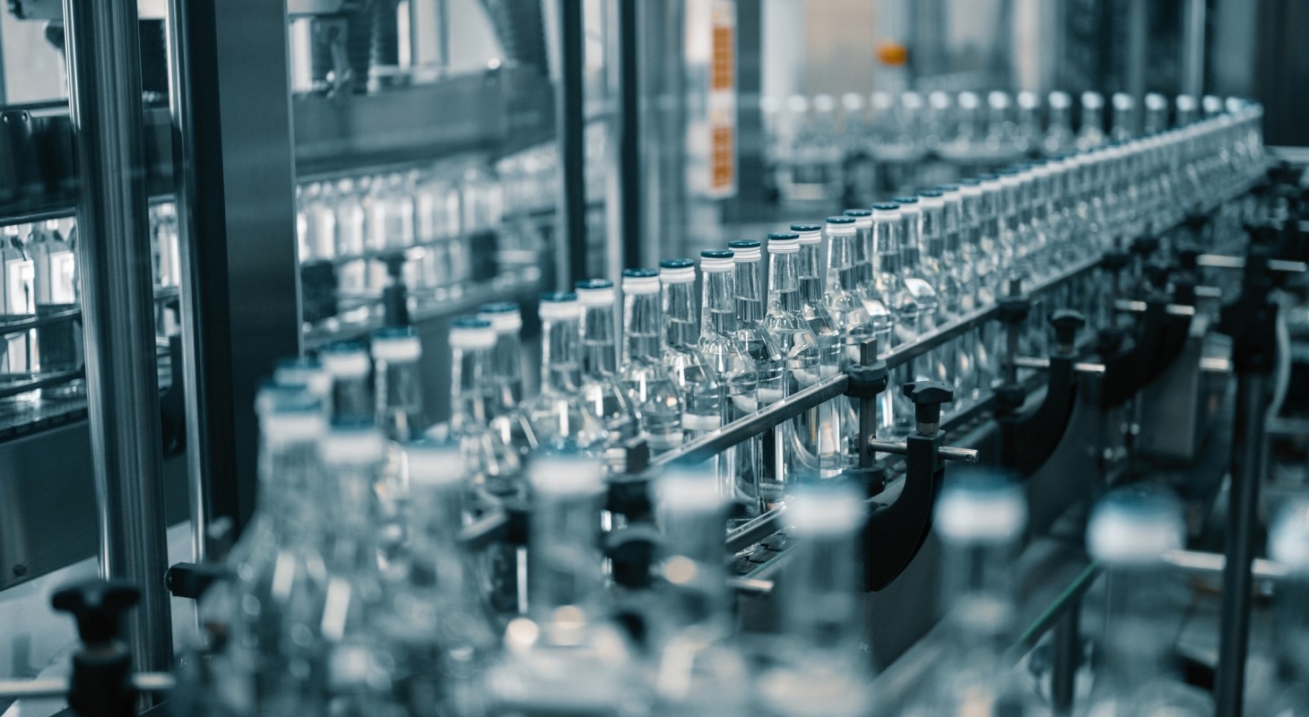 closed glass bottles of upscale vodka transported by line