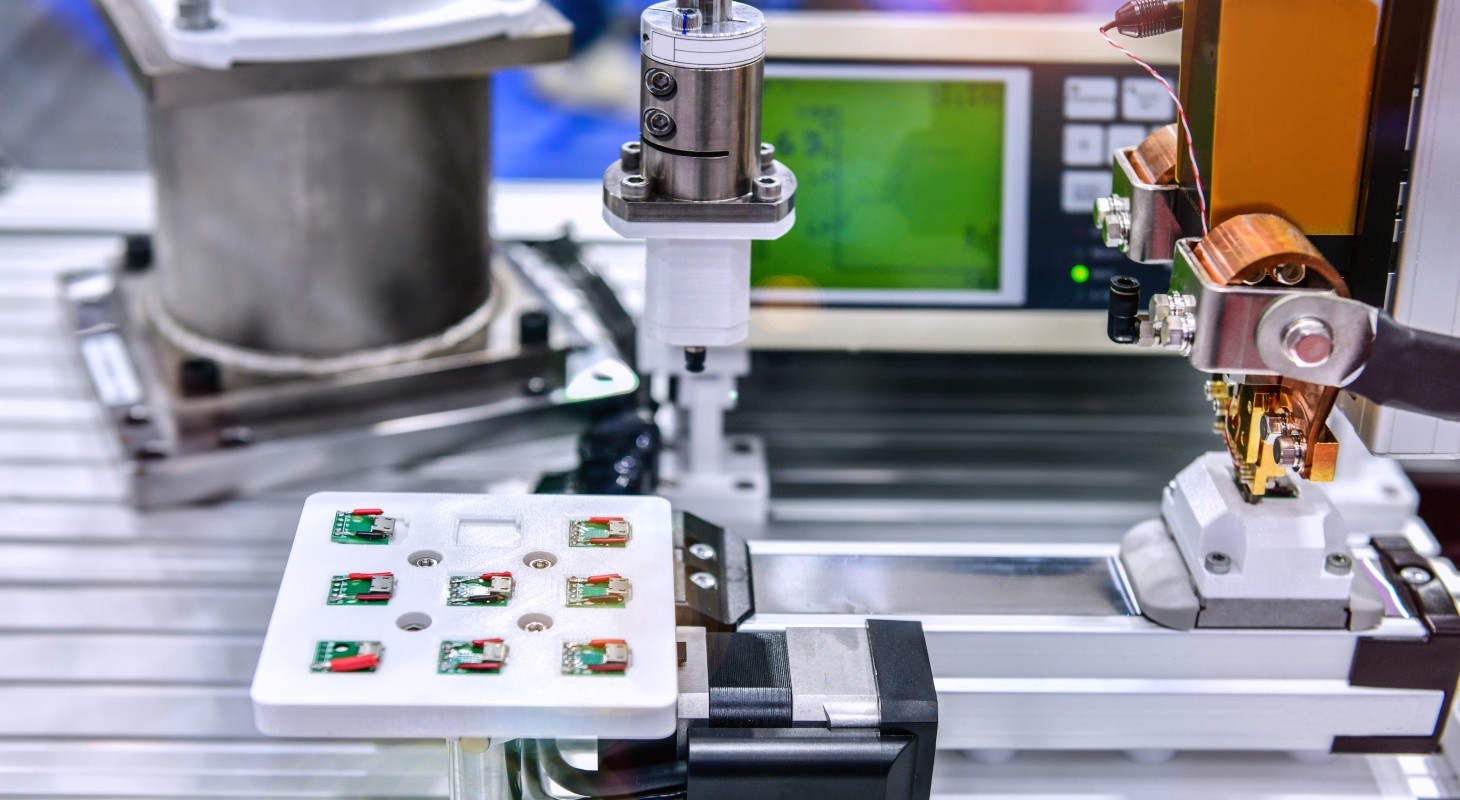 circuit board being assembled by robotic arm