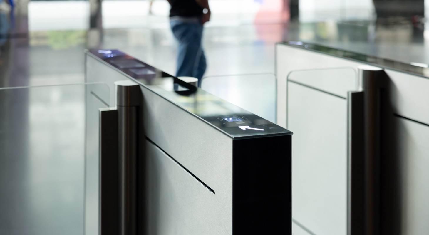 A man walks past a pair of electronic turnstiles