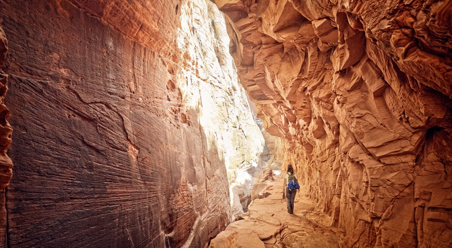 female hiker walking through red canyon