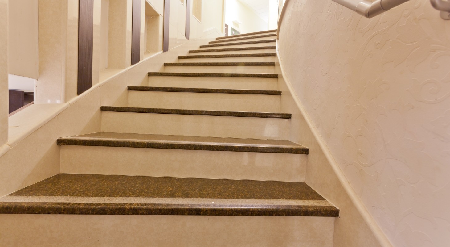 curved marble staircase leading to lighted landing 