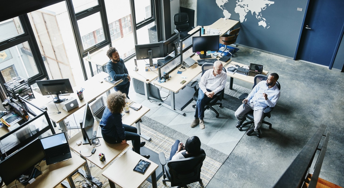 coworkers having informal project meeting in high tech office overhead view