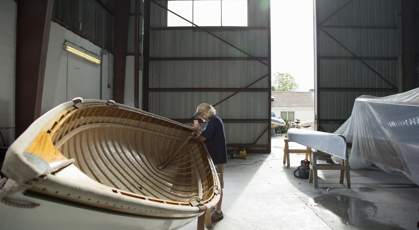 Mature male handcrafting wooden boat