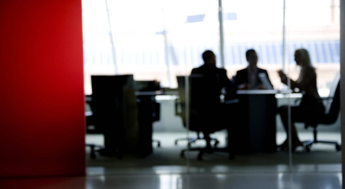 blurred image of three directors meeting in a board room