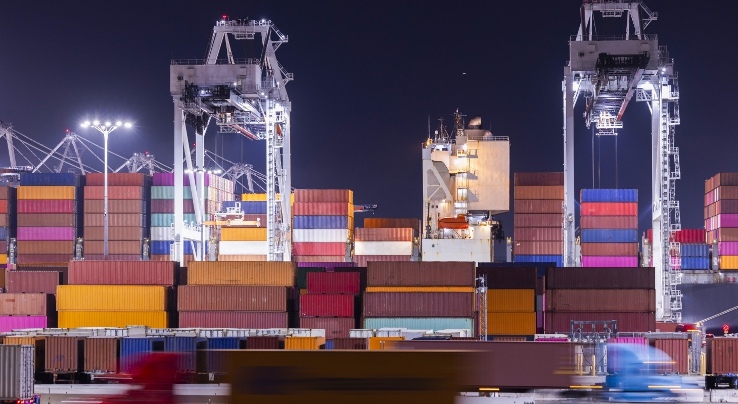 brightly colored shipping containers on dock at night
