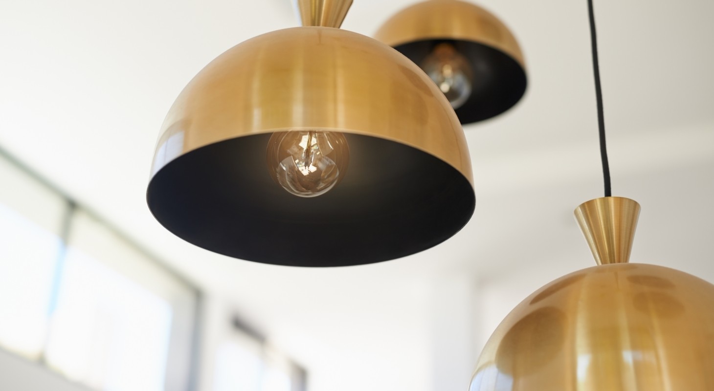 three brass pendant lights hanging at different levels