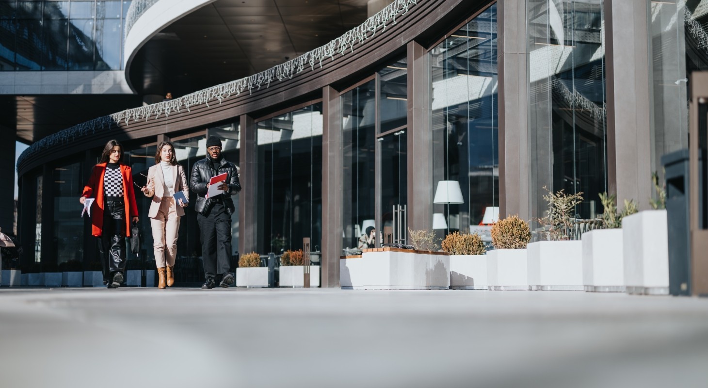 three colleagues walking together outside a modern office building