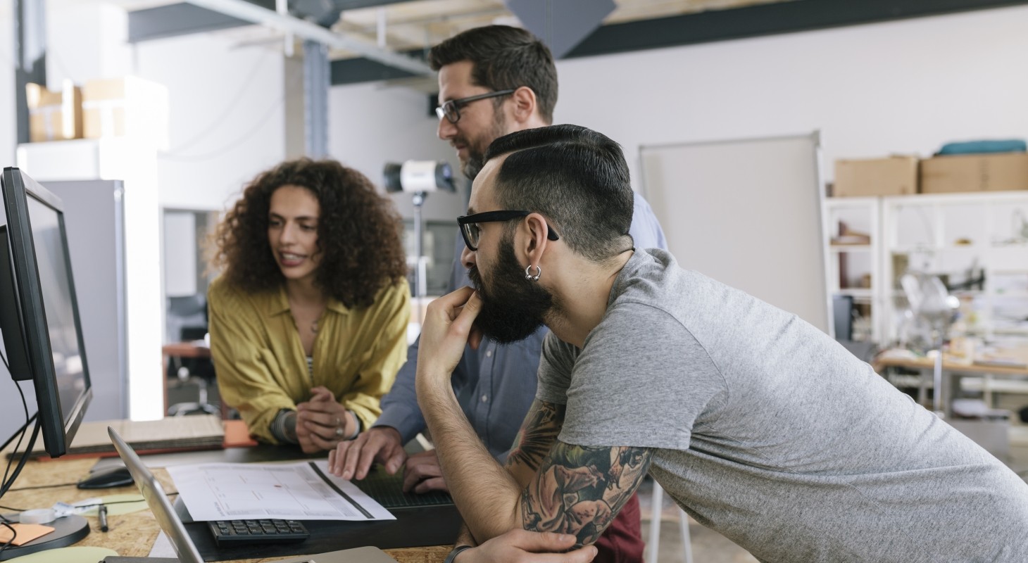 three tech startup colleagues collaborating on a work project