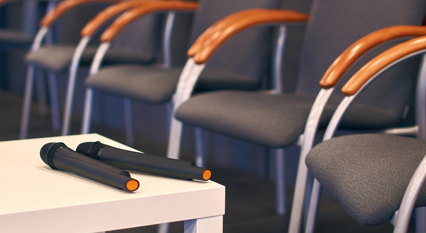 two microphones on a table with conference chairs nearby