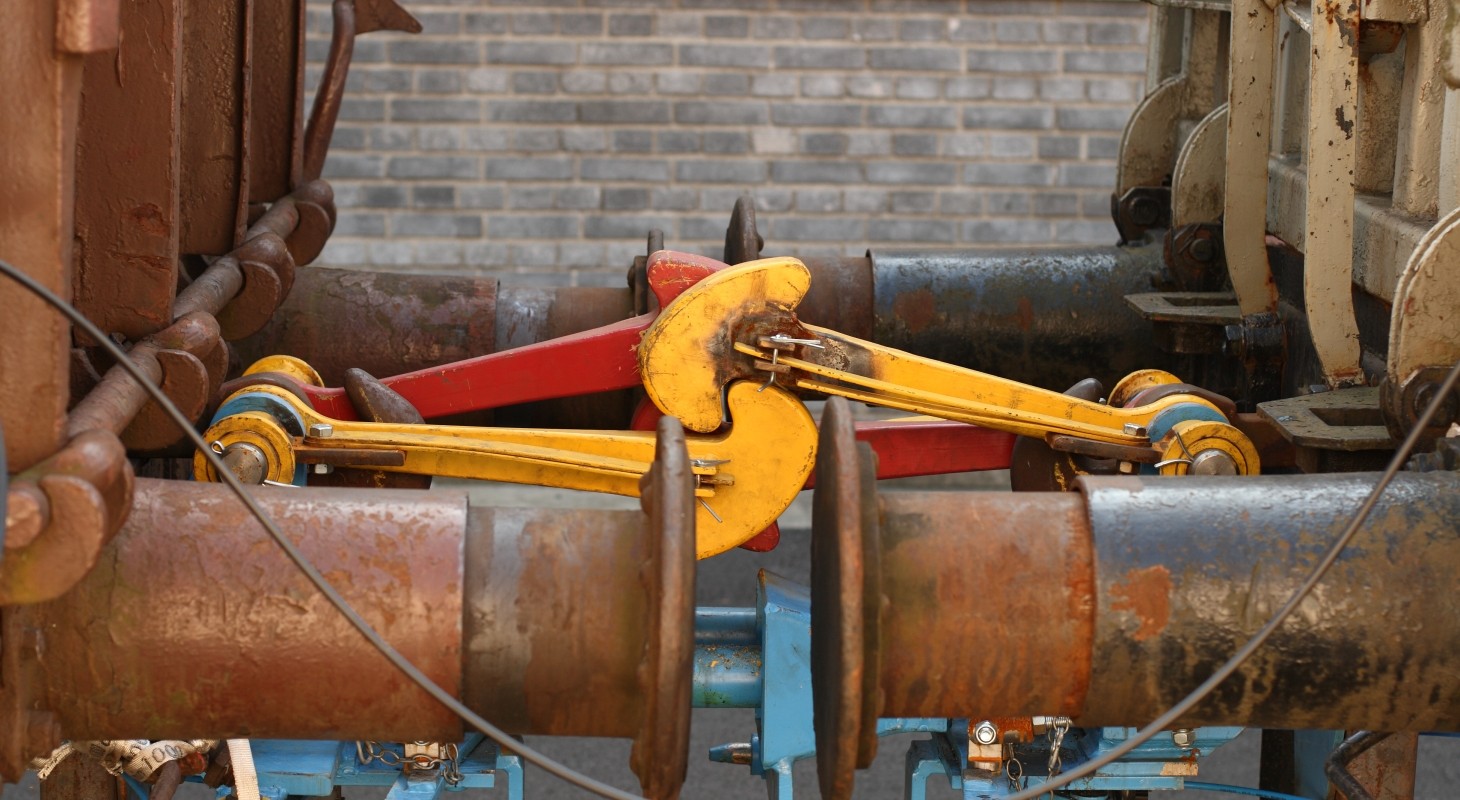 rusty railroad car buffers with components painted blue yellow and red