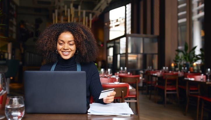 woman looking to a computer in a restaurant