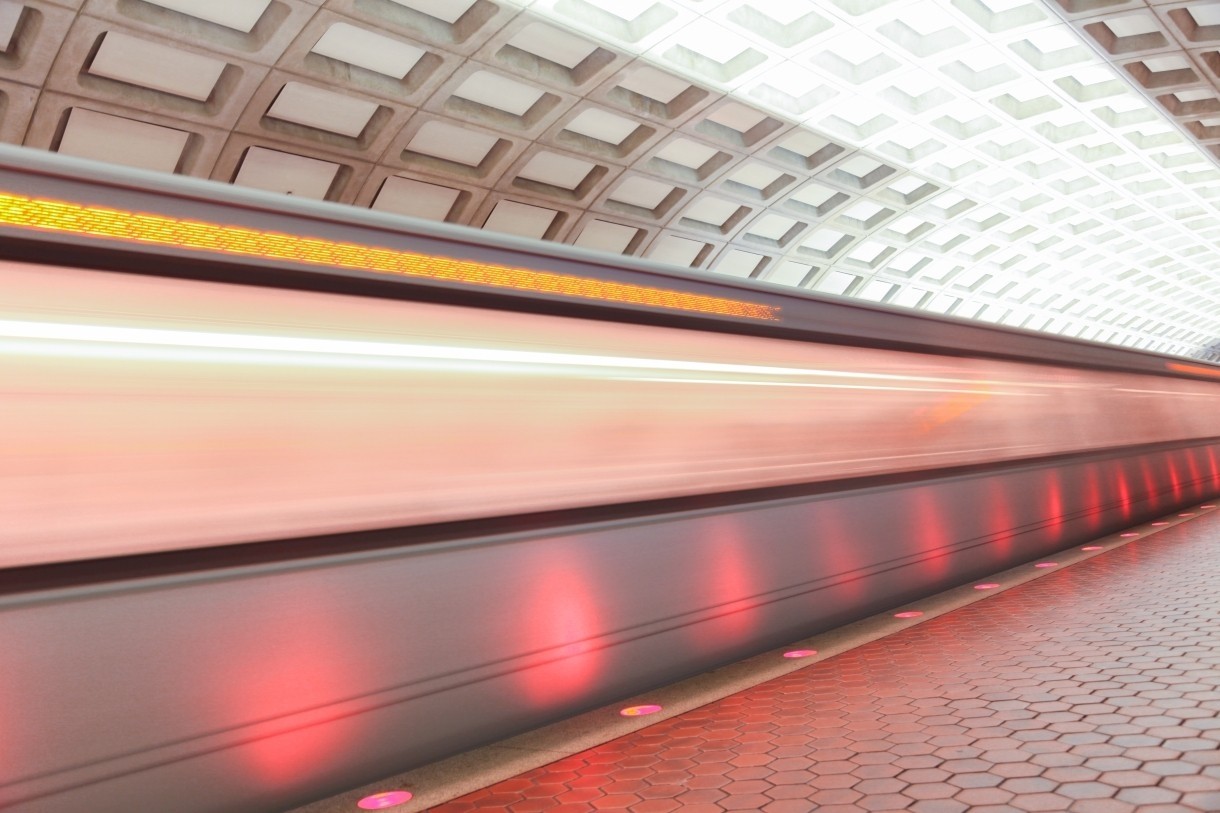 high speed train in subway station with red lights and doomed ceiling