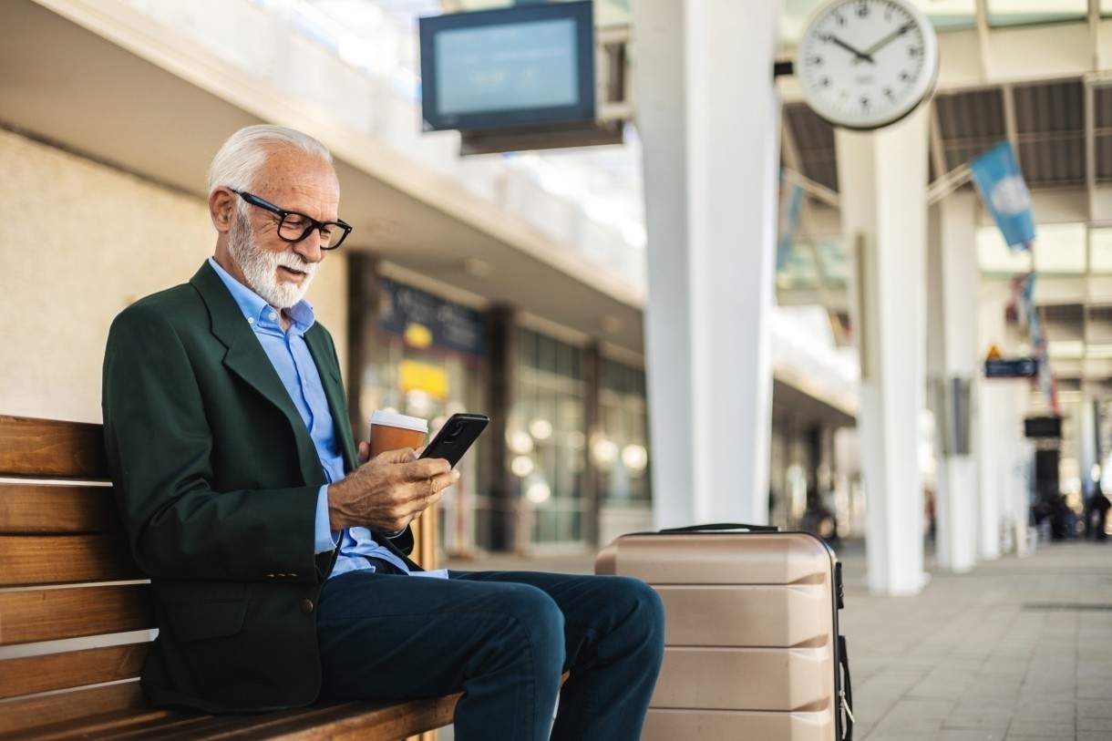 a man in suit with glasses waiting outside airport