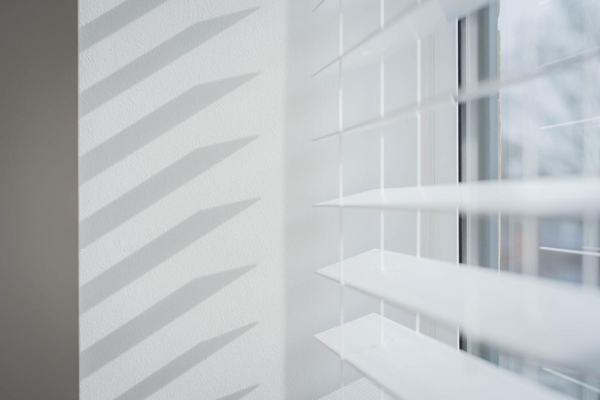open white blinds creating shadow on wall