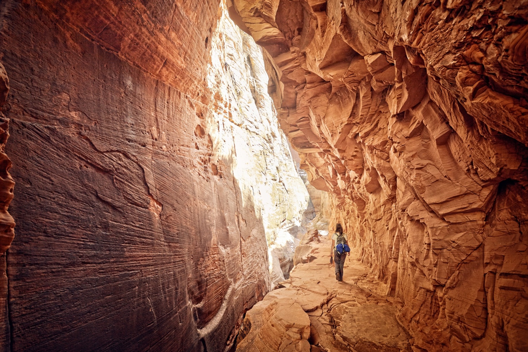 female hiker walking through red canyon