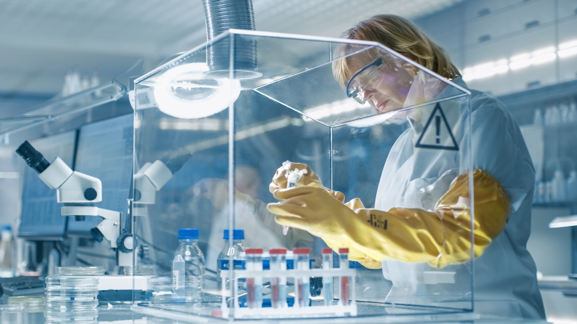 senior epidemiologist works with samples in isolation glove box