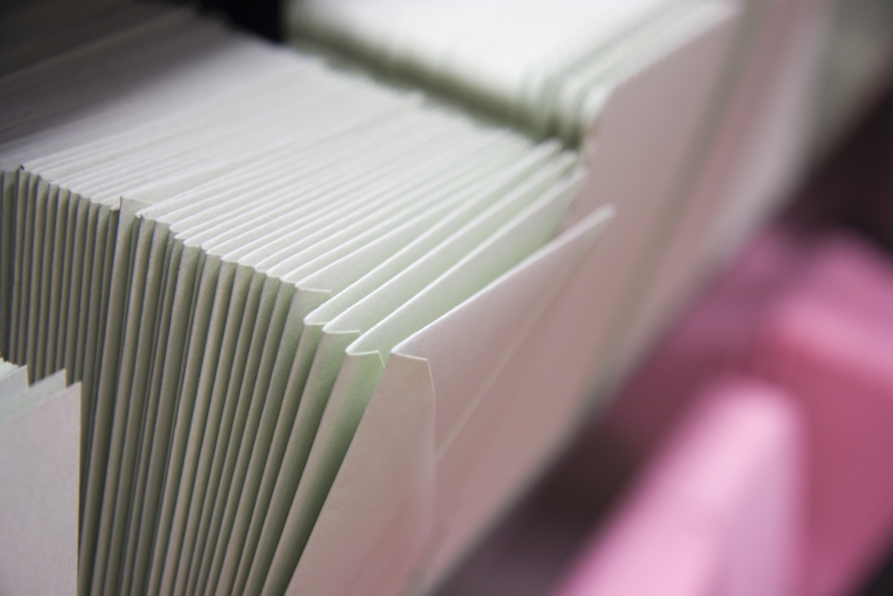 stacked envelopes on pink shelf