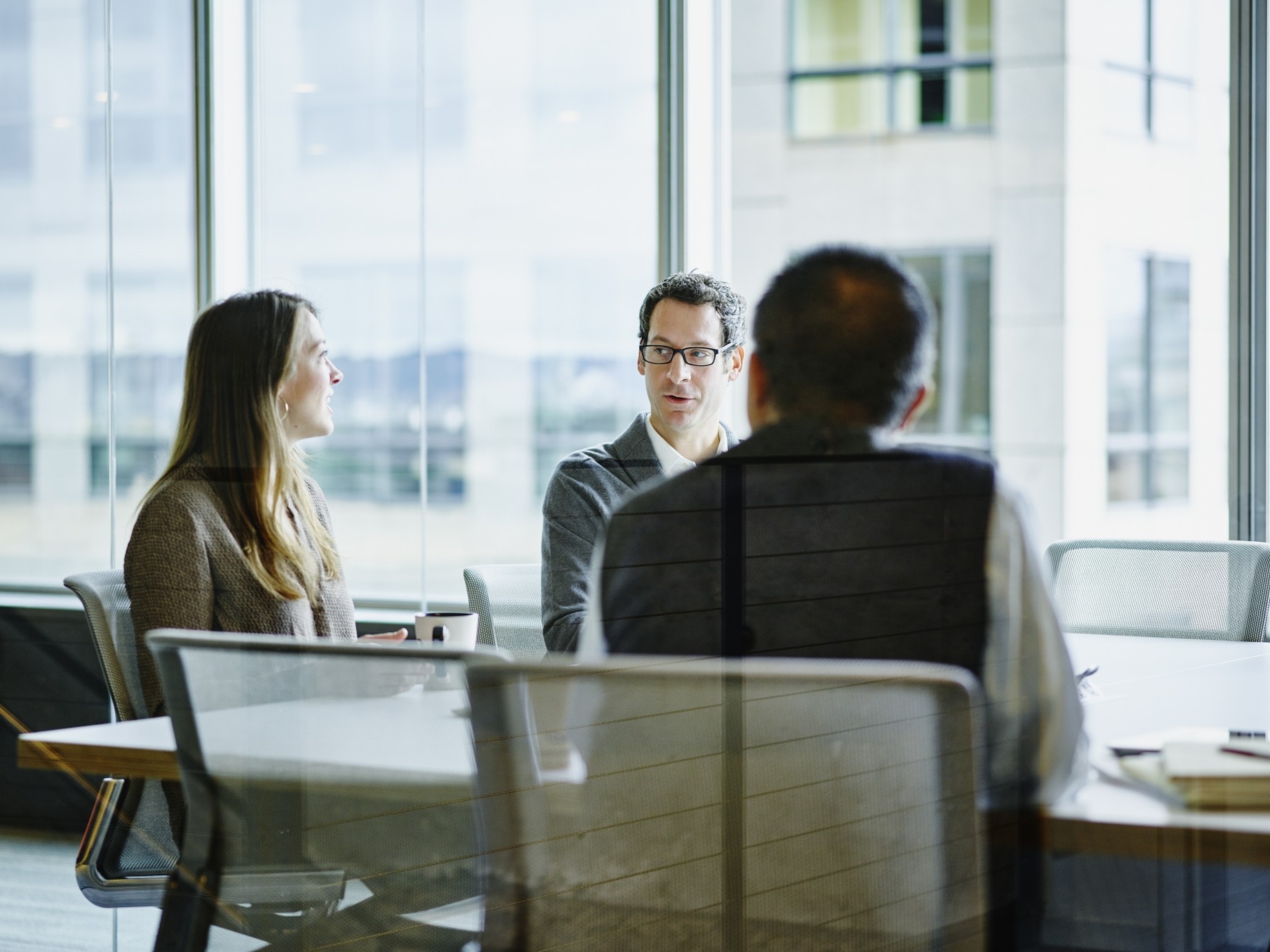 three board directors talking in conference room