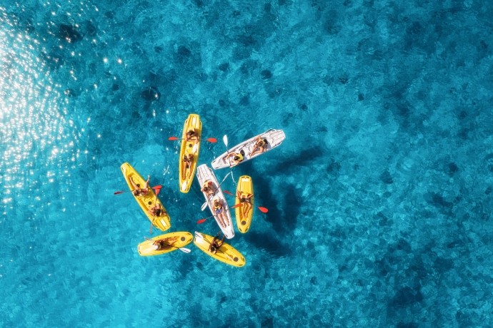aerial view of seven kayaks on clear blue water