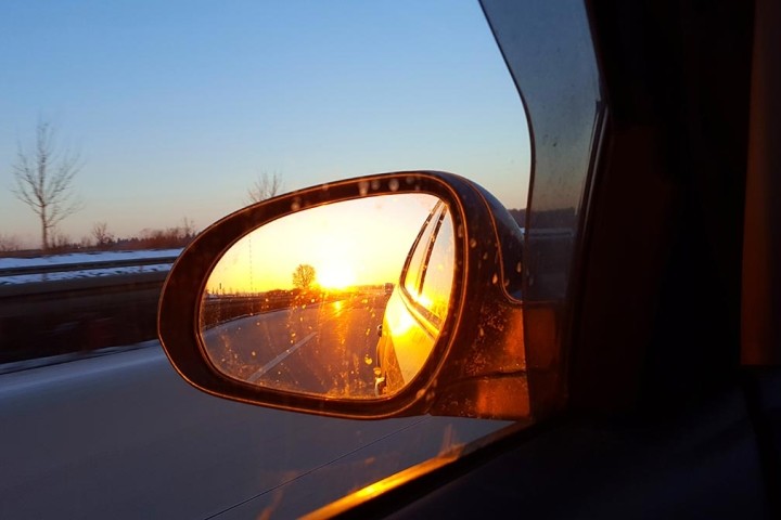 sunset reflected in car rearview mirror