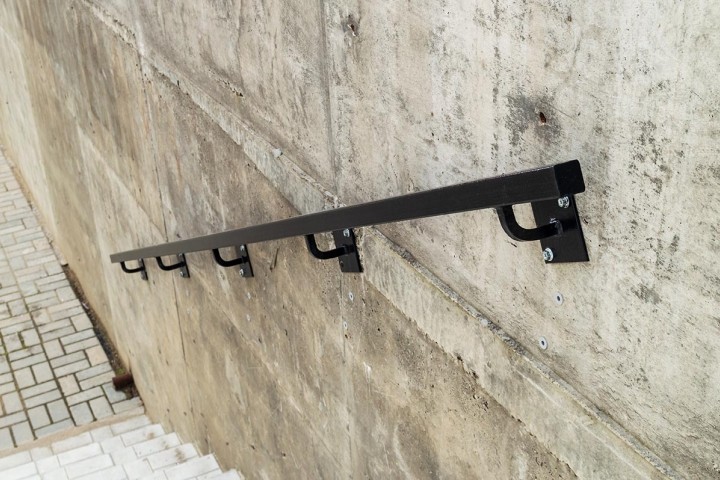 black metal handrail on concrete wall