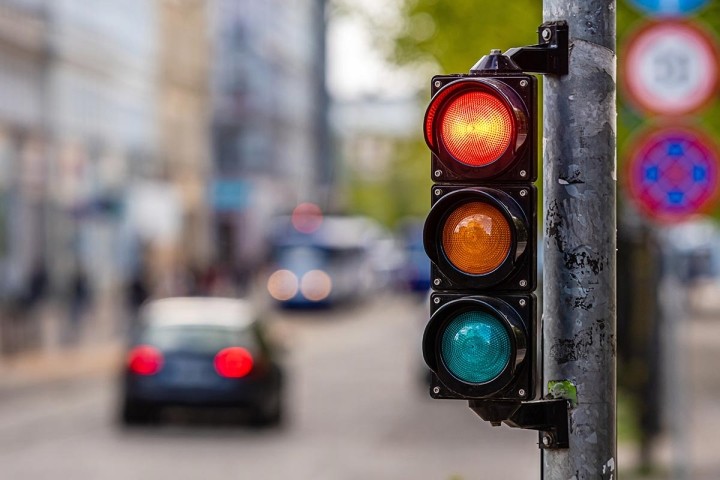 red traffic light with blurred car in background