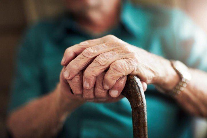 close up of elderly gentlemans hands on cane