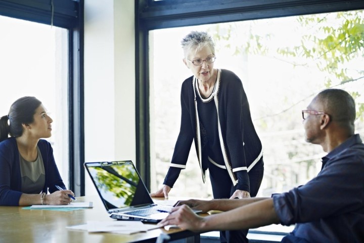 strong female executive talking with two colleagues