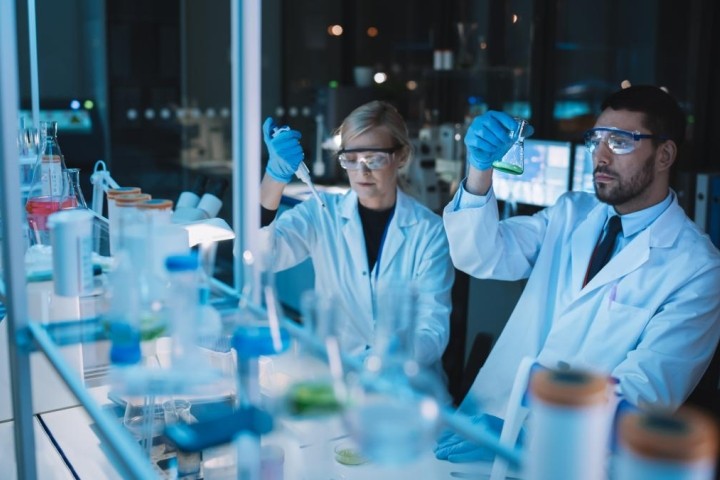 female and male researchers in lab under blue light