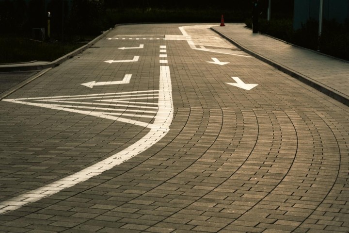 asphalt road with white directional markings for straight and right turn