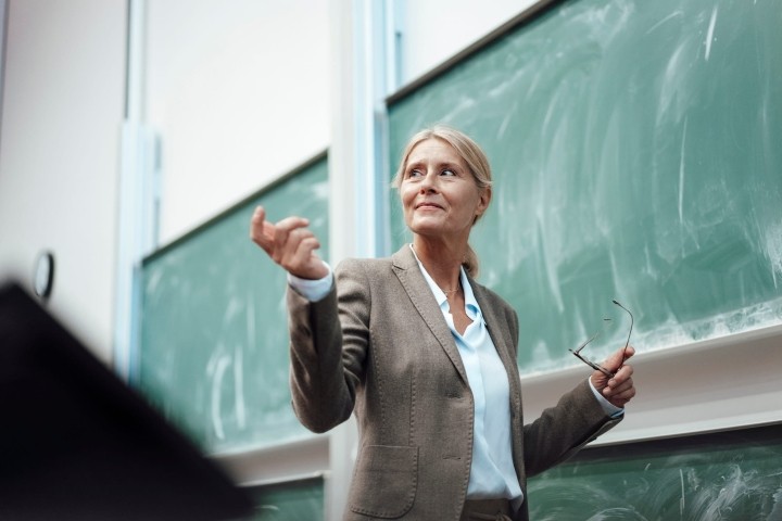 businesswoman giving presentation by chalkboard