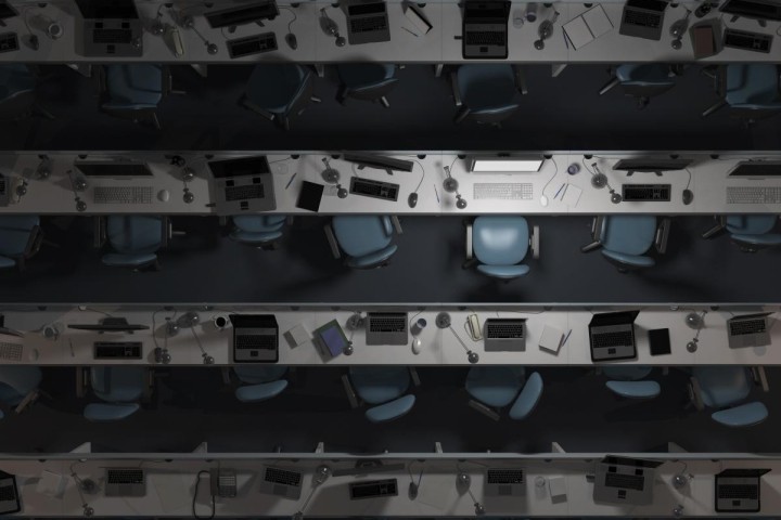 rows of dark empty workstations with blue chairs