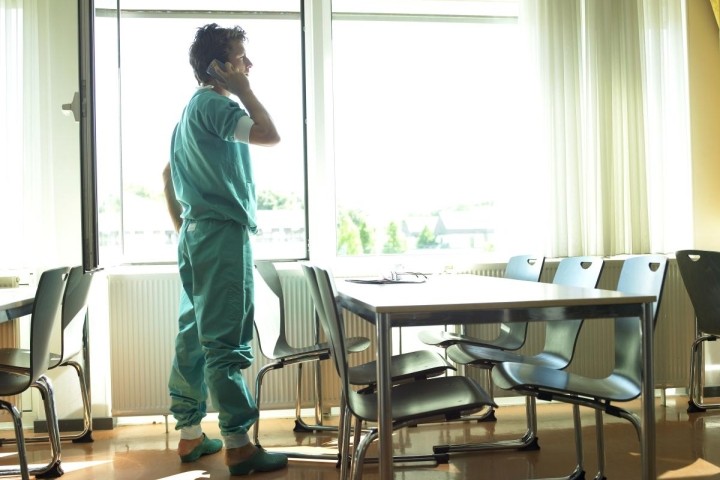 healthcare worker in green scrubs in hospital cafeteria