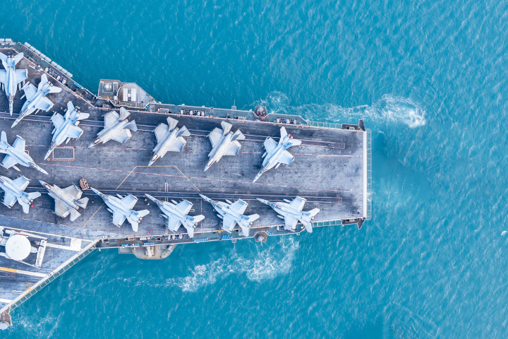 military navy ship carrying fighter jets