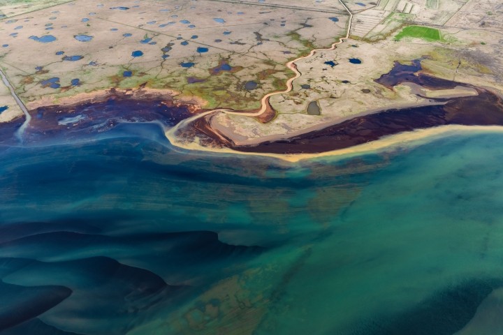 aerial shot of a coastal plain filled with blue ponds
